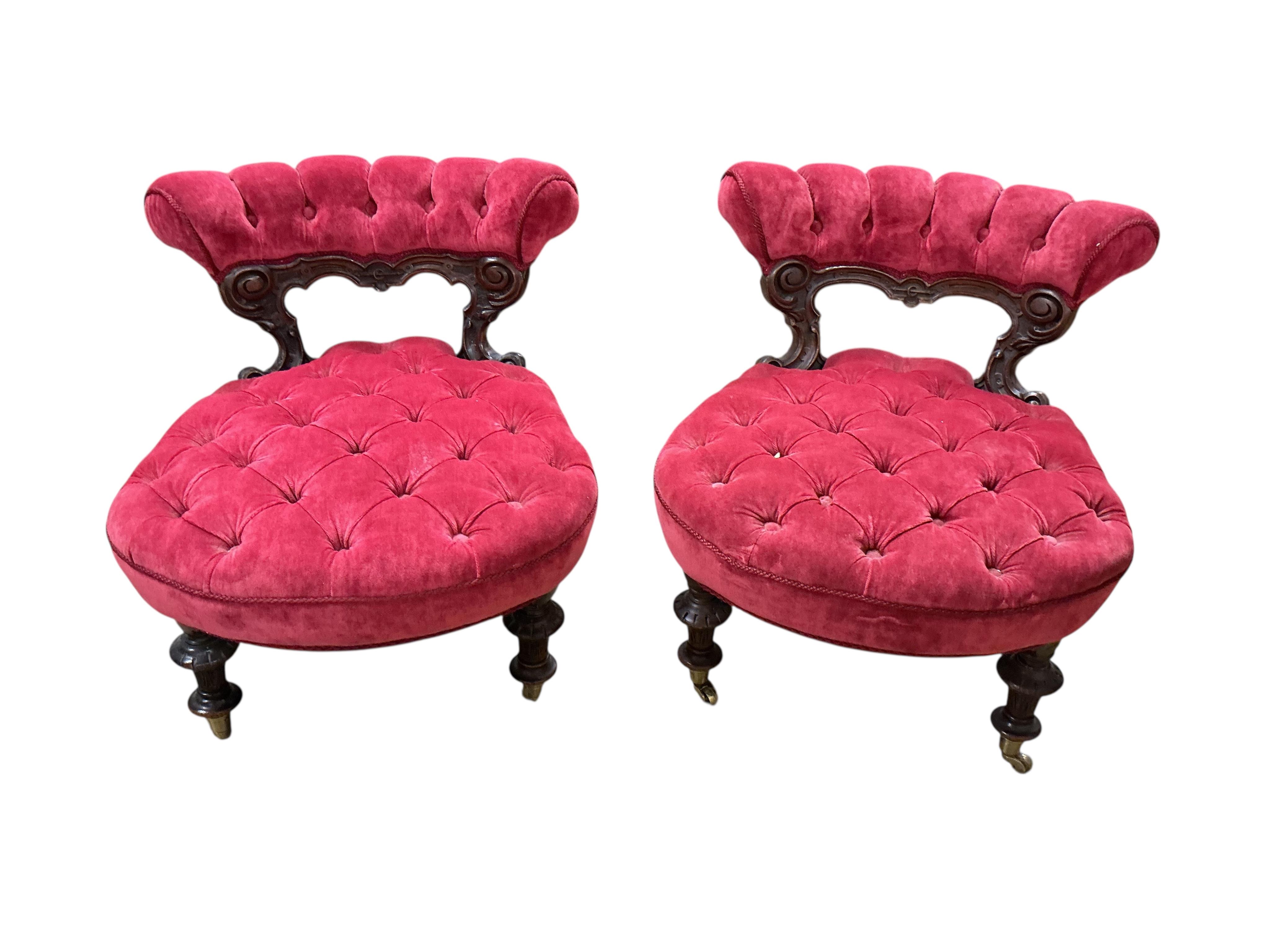 A pair of Victorian velvet slipper chairs with brass castors, width 50cm, depth 54cm, height 59cm.